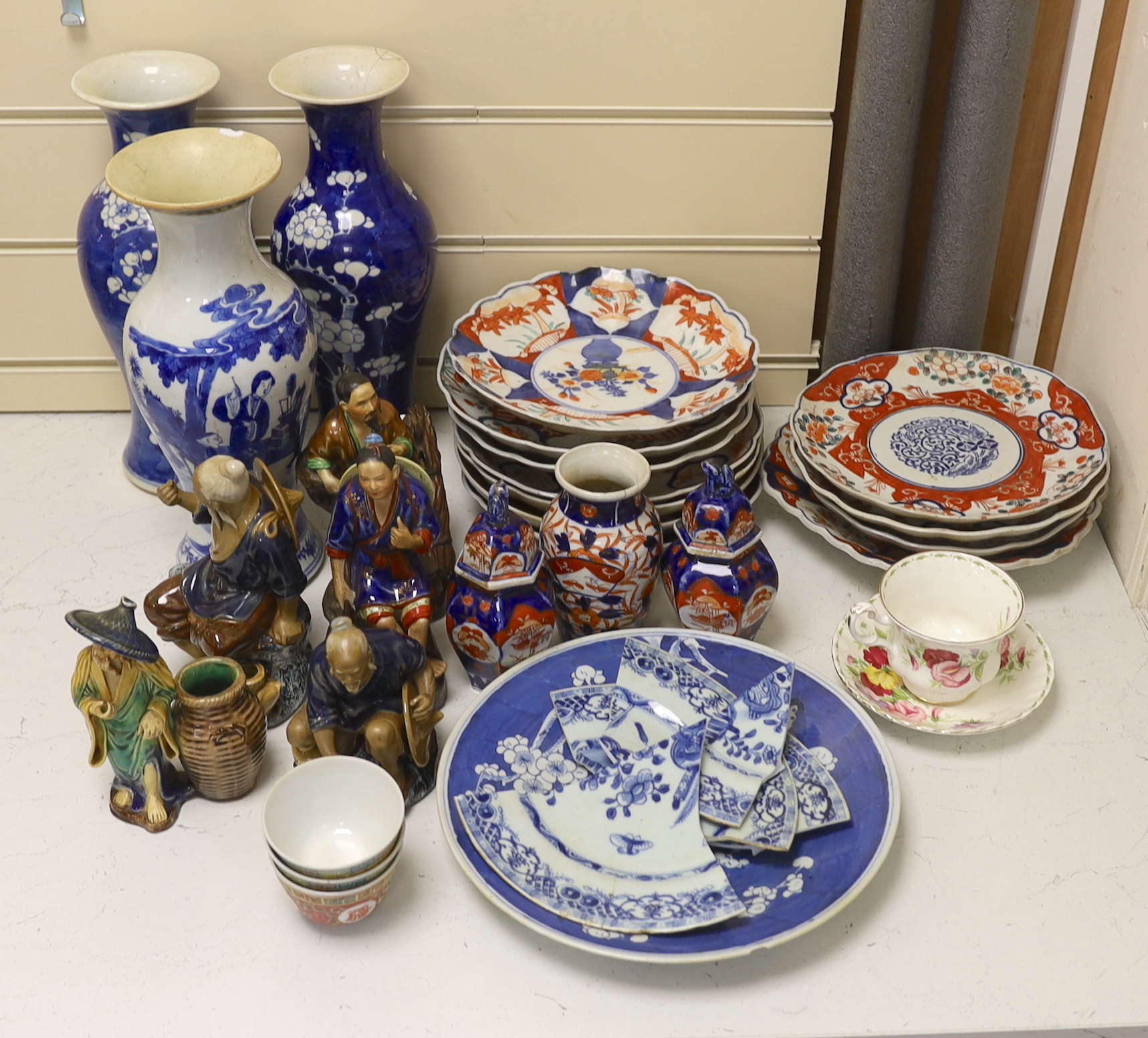 A collection of Chinese and Japanese pottery and porcelain including three vases, five figures, plates and bowls, vases 30cm